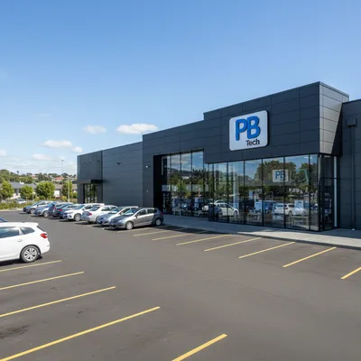 The storefront of the large PB Tech building on Hillside Road in South Dunedin, with clear signage and customer parking available in front.